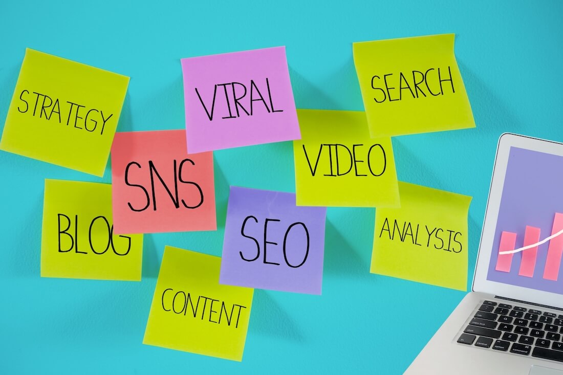 ノートパソコン壁にたくさんの付箋が貼ってある画像